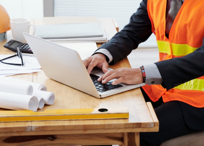 Un professionnel utilise son ordinateur sur un chantier