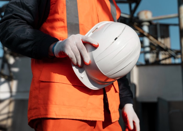 personne tenant un casque de chantier